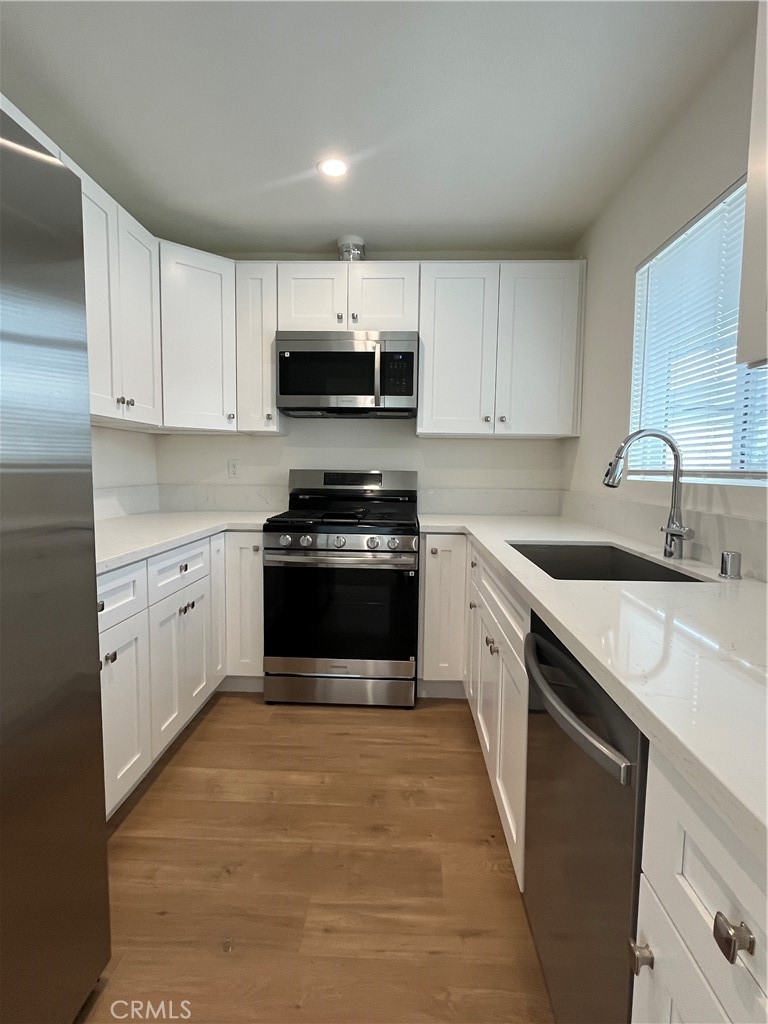 1011 East Chevy Chase Drive, Unit B Glendale, CA 91205 - Photo 5 of 11 a kitchen with stainless steel appliances a white stove top oven and cabinets