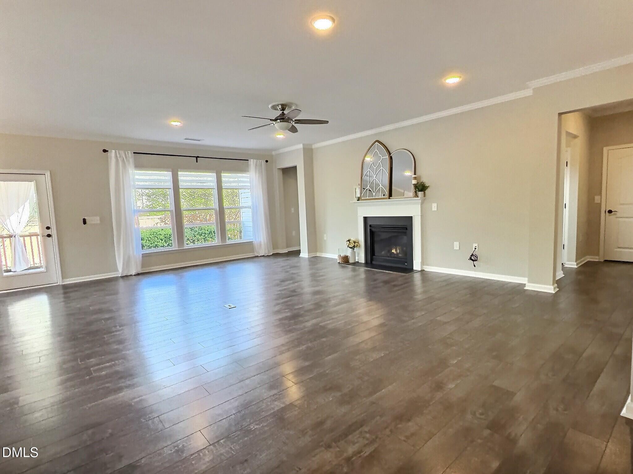 236 Oakmere Drive Cary, NC 27513 - Photo 14 of 49 an empty room with wooden floor fireplace and windows