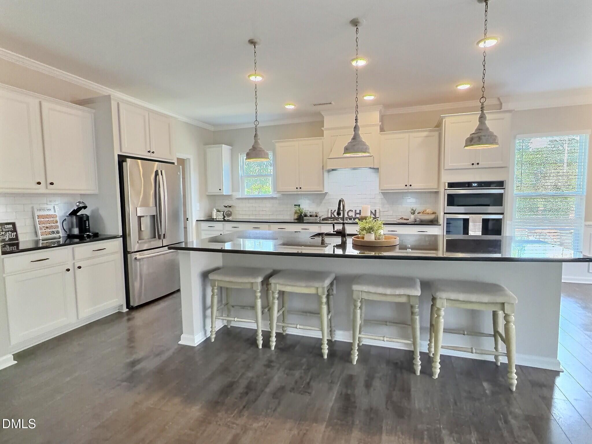 236 Oakmere Drive Cary, NC 27513 - Photo 8 of 49 a kitchen with stainless steel appliances granite countertop a stove a sink a refrigerator and white cabinets with wooden floor