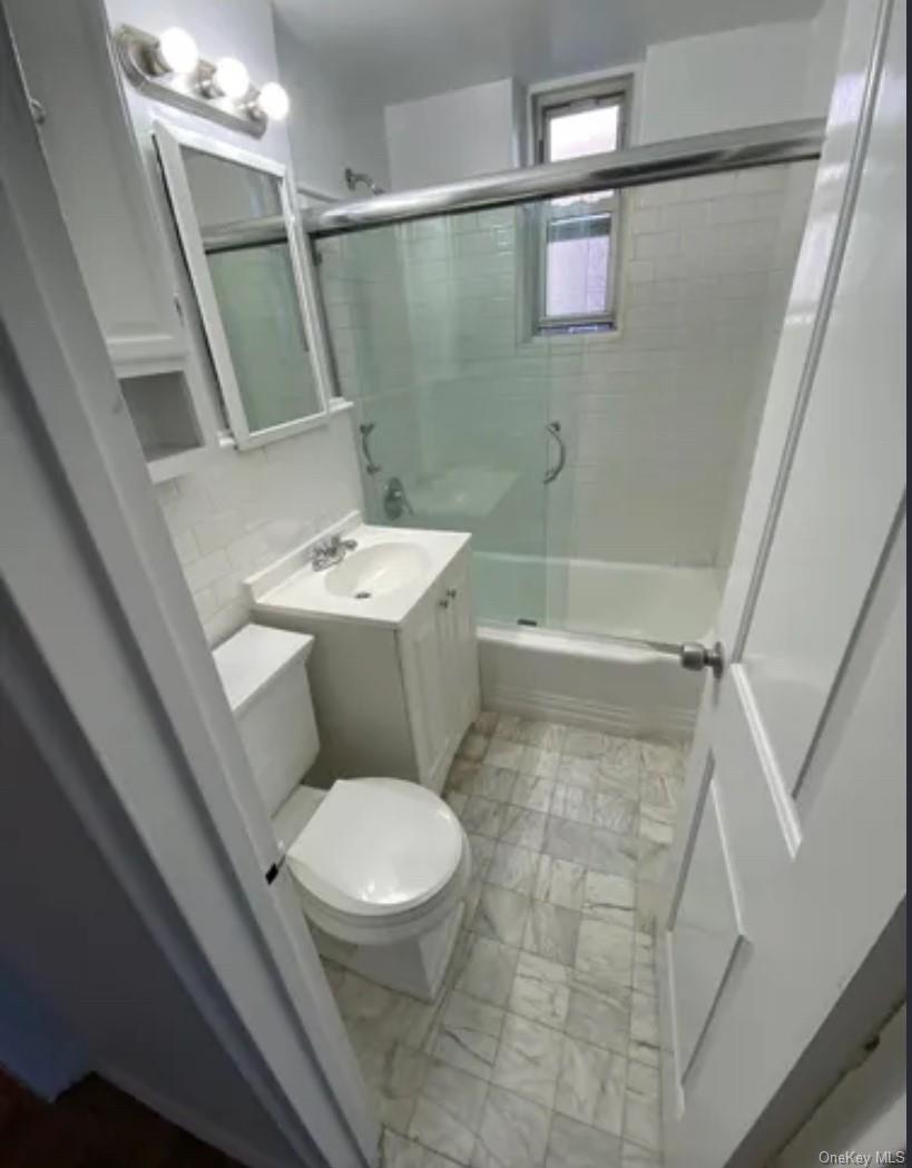 220 Pelham Road, Unit 3F New Rochelle, NY 10805 - Photo 6 of 25 Bathroom with toilet, marble finish flooring, enclosed tub / shower combo, and vanity
