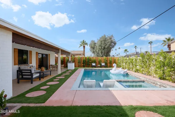 a view of a patio with couches table and chairs with wooden floor and fence