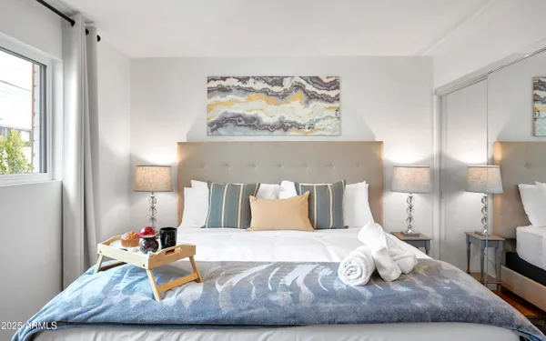 a bedroom with a bed and painting on the wall
