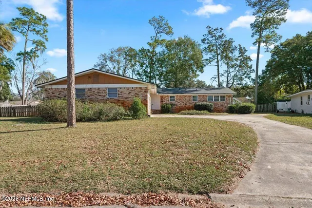 a view of a house with a yard and potted plants
