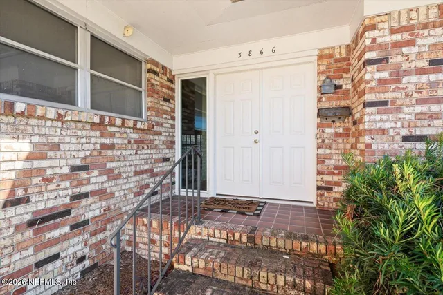 a view of a livingroom with wooden floor and furniture