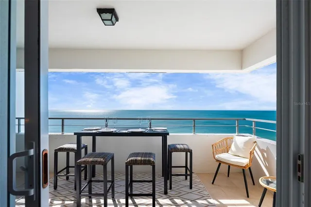 a view of balcony and dining space with furniture