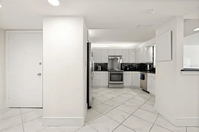 a kitchen with stainless steel appliances a refrigerator sink and white cabinets
