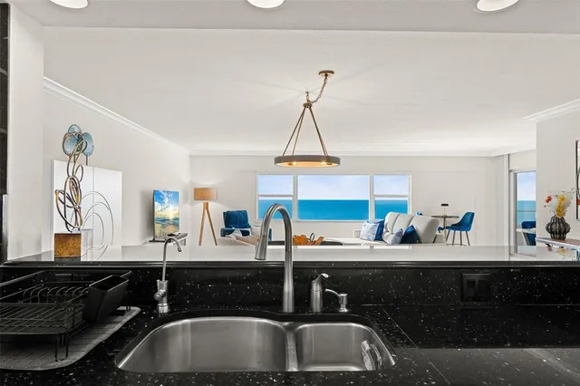 a kitchen with granite countertop white cabinets and stainless steel appliances