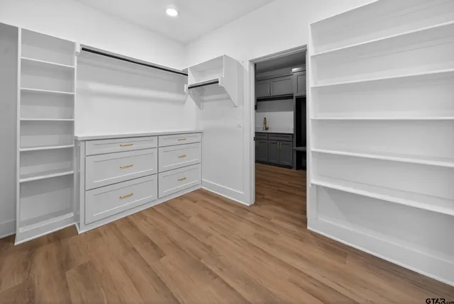 a view of a hallway with wooden floor and a chandelier