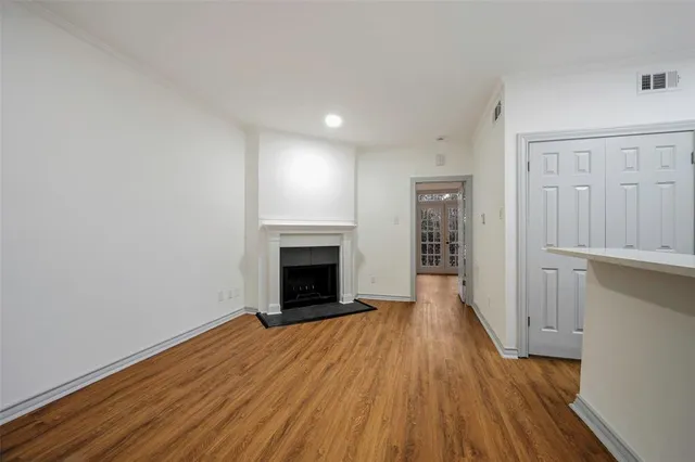a view of empty room with wooden floor and fireplace