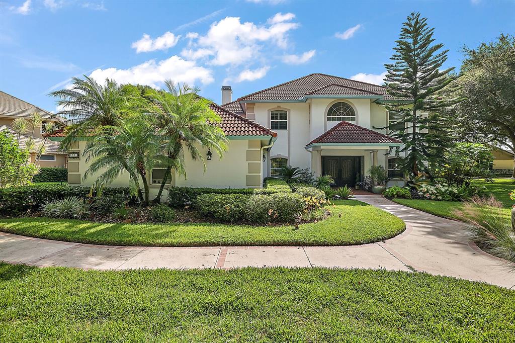 a front view of a house with a yard and potted plants