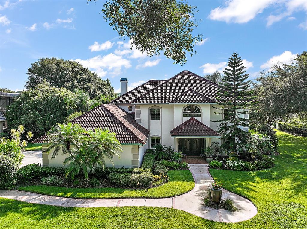 2701 Regal Point Place Eustis, FL 32726 - Photo 5 of 53 a front view of a house with a yard and potted plants