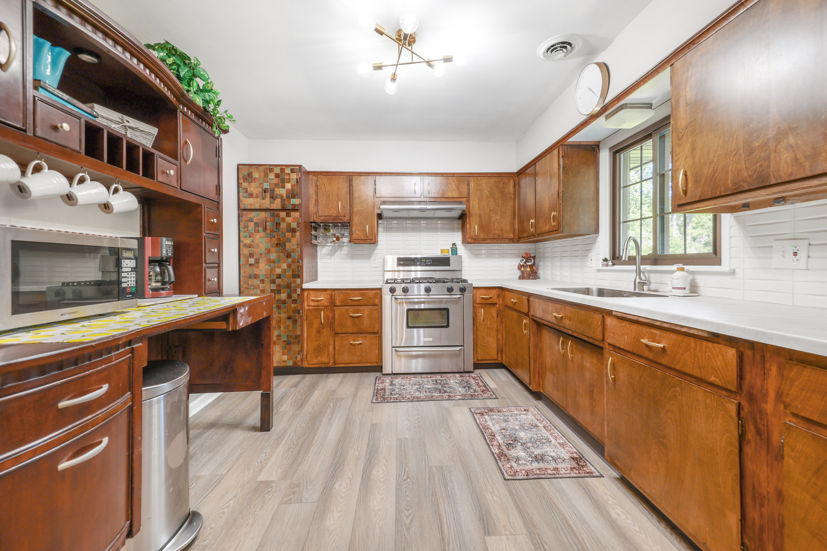 480 West Kennedy Road Braidwood, IL 60408 - Photo 10 of 25 a kitchen with stainless steel appliances a stove a sink dishwasher a microwave oven and a dining table with wooden floor