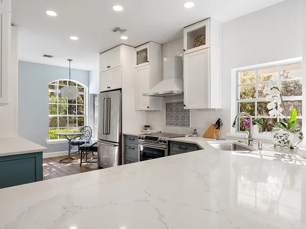 a kitchen with stainless steel appliances kitchen island granite countertop a sink stove and refrigerator