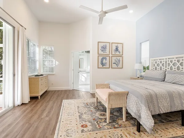 a spacious bedroom with a bed and wooden floor