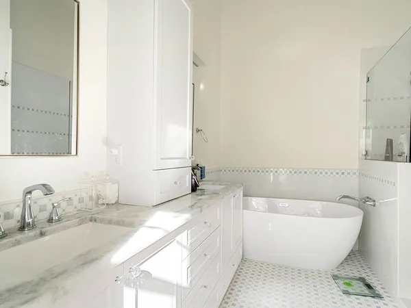 a bathroom with a granite countertop sink and a bathtub