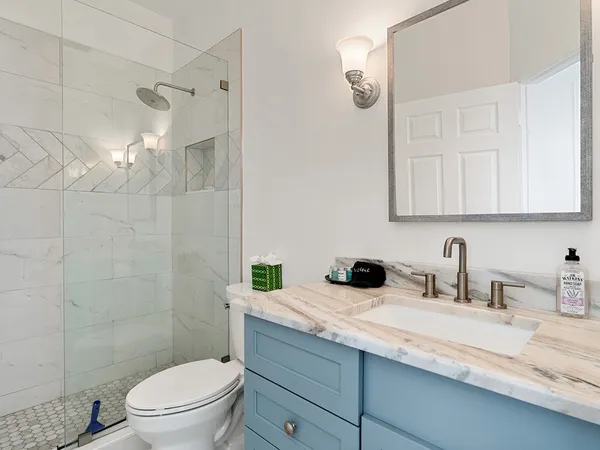a bathroom with a sink a toilet and shower