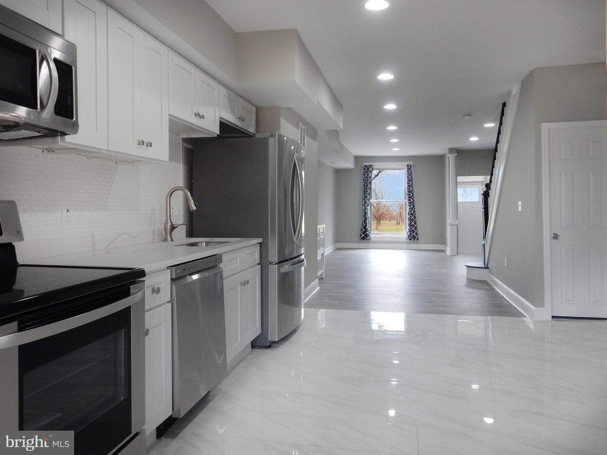 1111 Bayard Street Baltimore, MD 21223 - Photo 12 of 41 a kitchen with stainless steel appliances a refrigerator a stove a microwave and cabinets