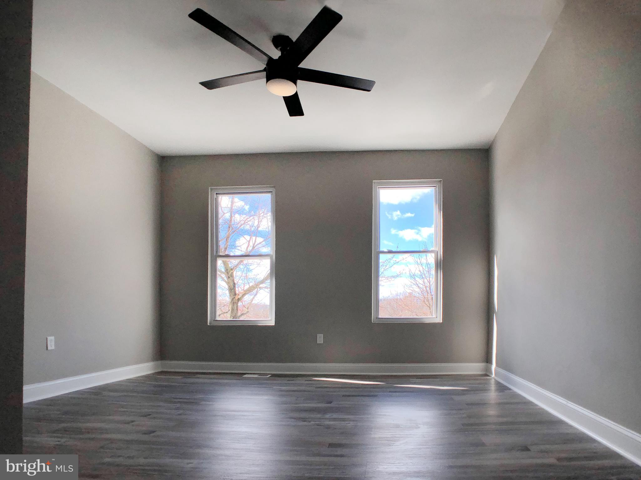 1111 Bayard Street Baltimore, MD 21223 - Photo 17 of 41 an empty room with wooden floor and windows