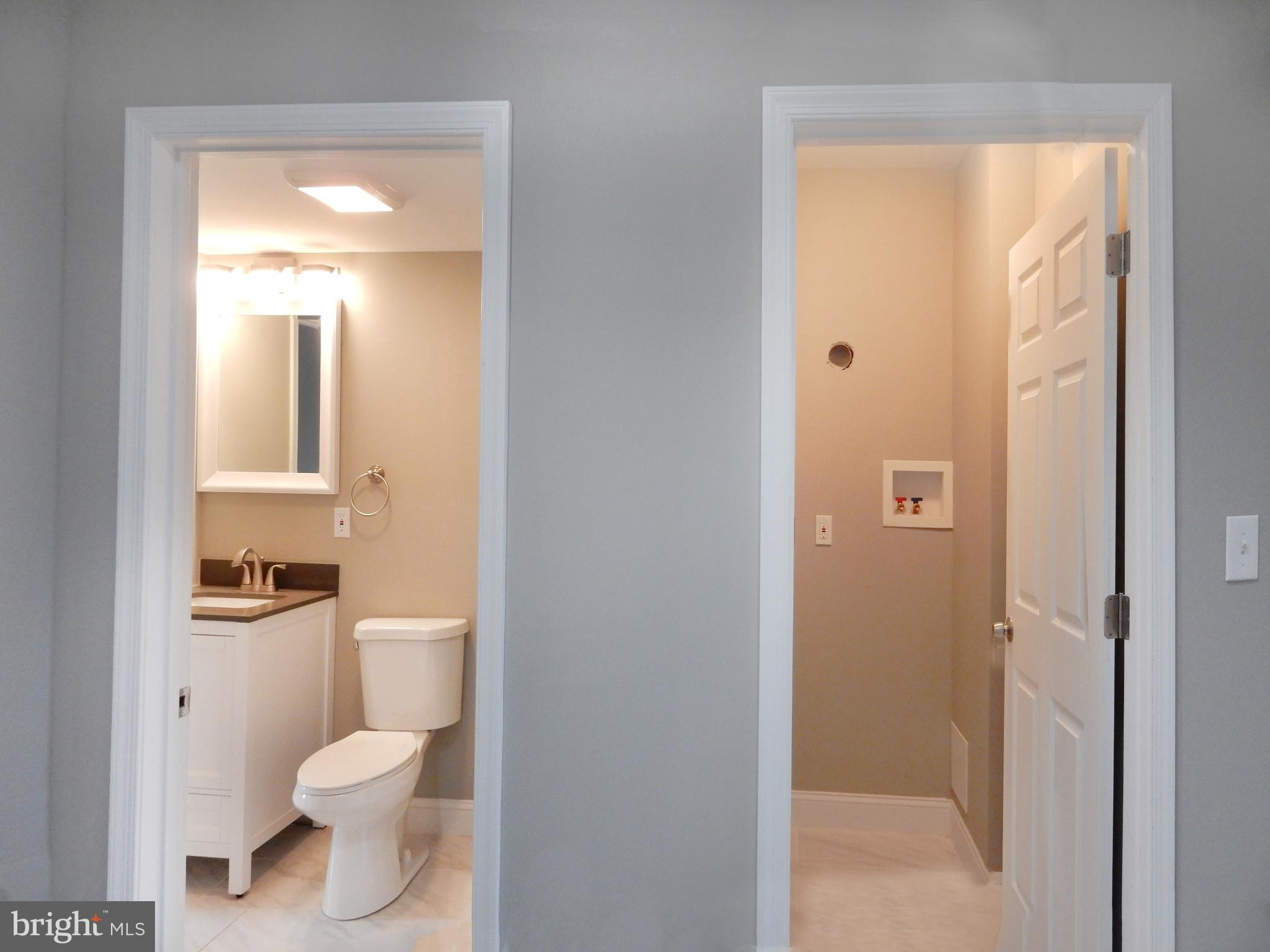 1111 Bayard Street Baltimore, MD 21223 - Photo 28 of 41 a bathroom with a toilet sink vanity and mirror