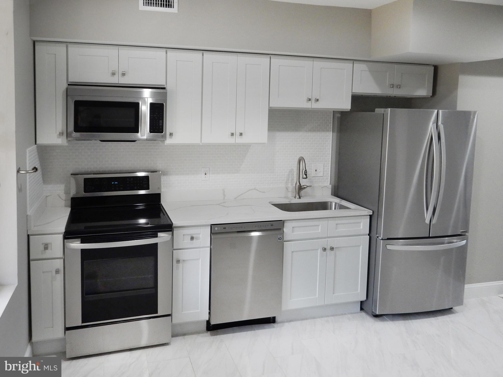 1111 Bayard Street Baltimore, MD 21223 - Photo 9 of 41 a kitchen with stainless steel appliances white cabinets and a stove