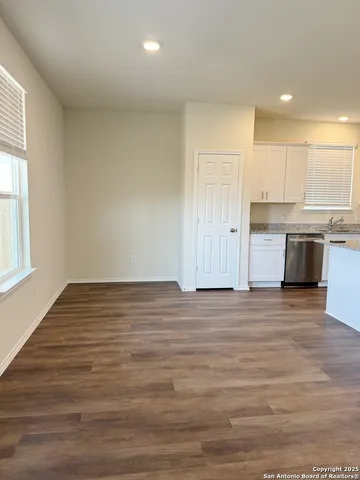 a view of a kitchen with wooden floor and a window