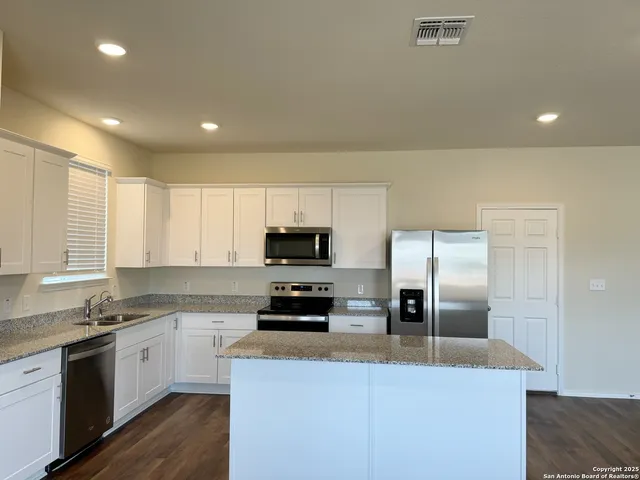 a kitchen with kitchen island a sink stainless steel appliances and window