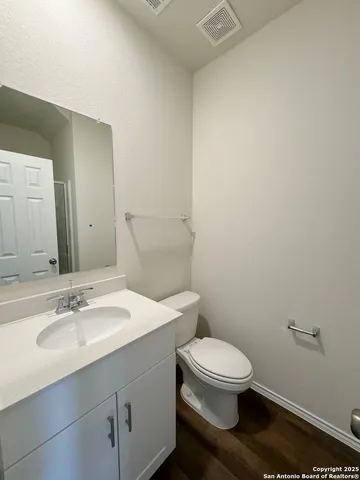 a bathroom with a toilet a sink and mirror