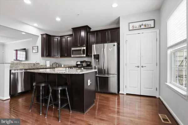 a kitchen with stainless steel appliances granite countertop a refrigerator and a stove top oven