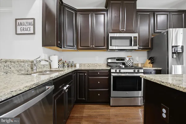 a kitchen with granite countertop stainless steel appliances and wooden cabinets