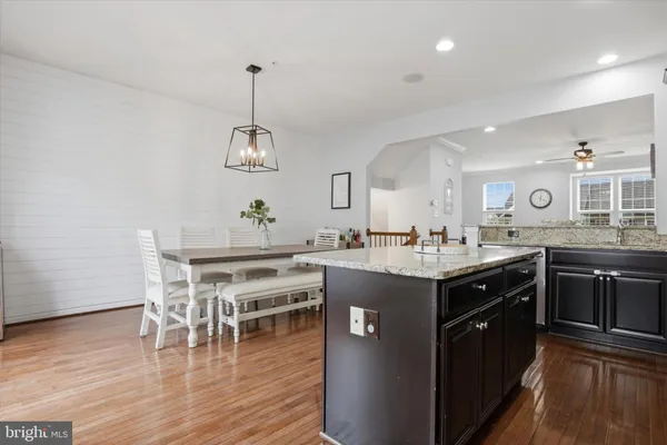 a kitchen with stainless steel appliances granite countertop a kitchen island a stove and a wooden floors