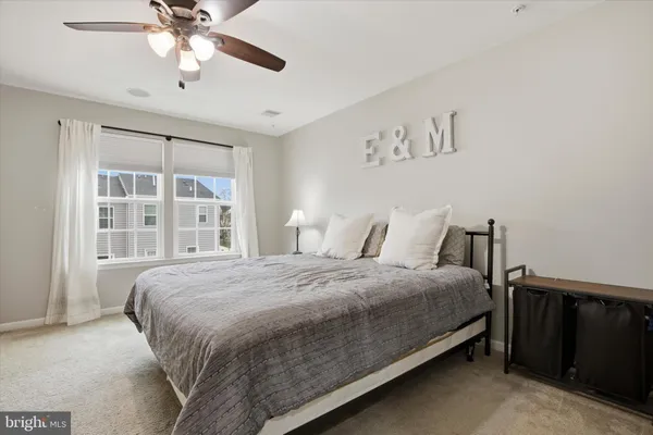 a bedroom with a large bed and a chandelier fan