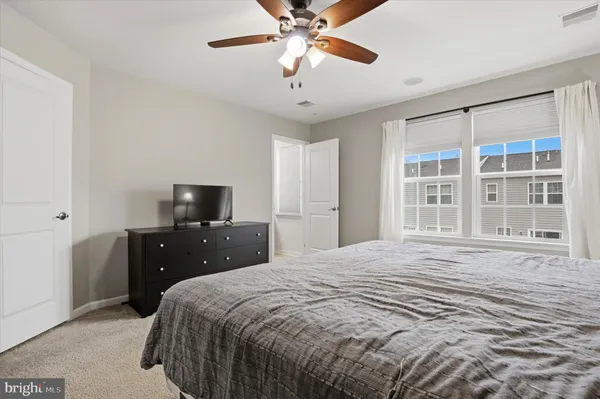 a bedroom with a bed and a flat tv screen on dresser