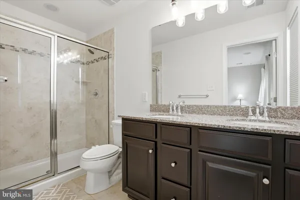a bathroom with a granite countertop sink toilet and shower