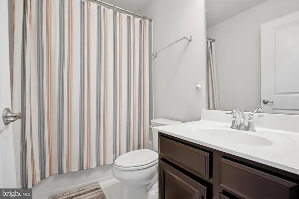 a bathroom with a sink a toilet and shower curtain