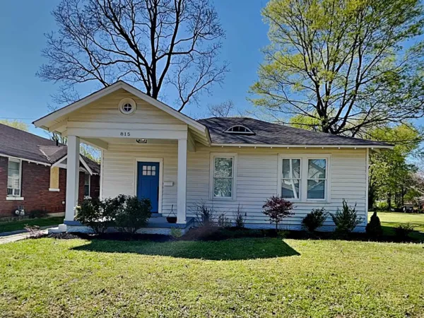a front view of a house with yard and green space