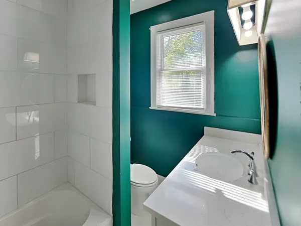 a bathroom with a tub sink and window