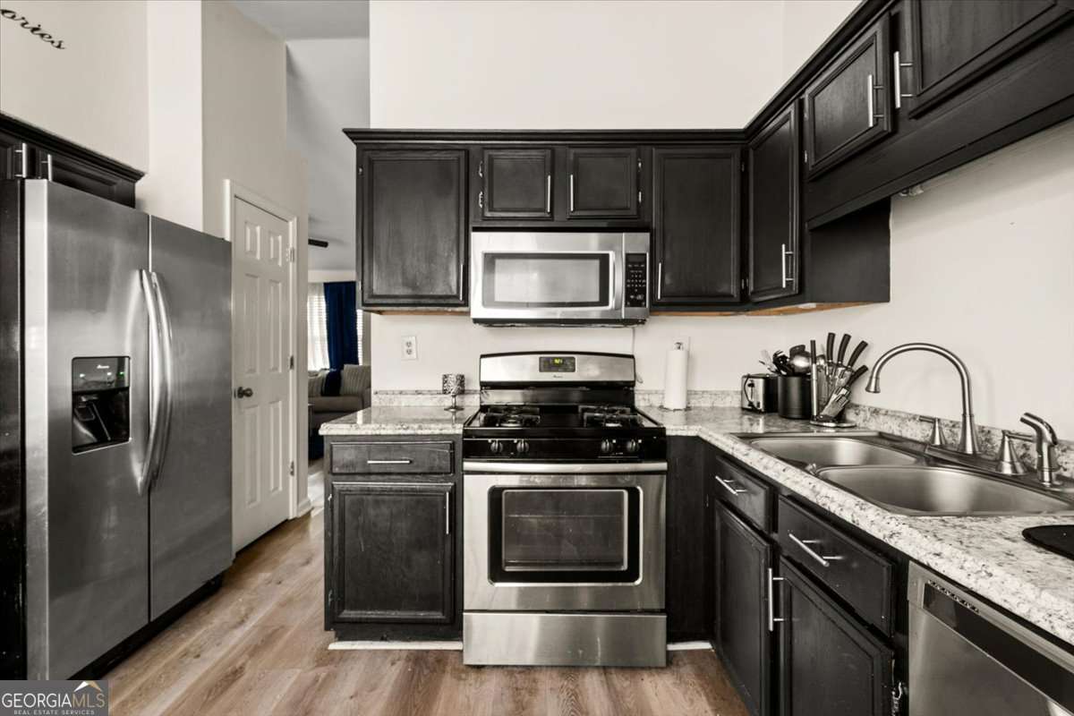 1362 Tara Road Jonesboro, GA 30238 - Photo 13 of 30 a kitchen with stainless steel appliances a stove a sink a refrigerator and cabinets