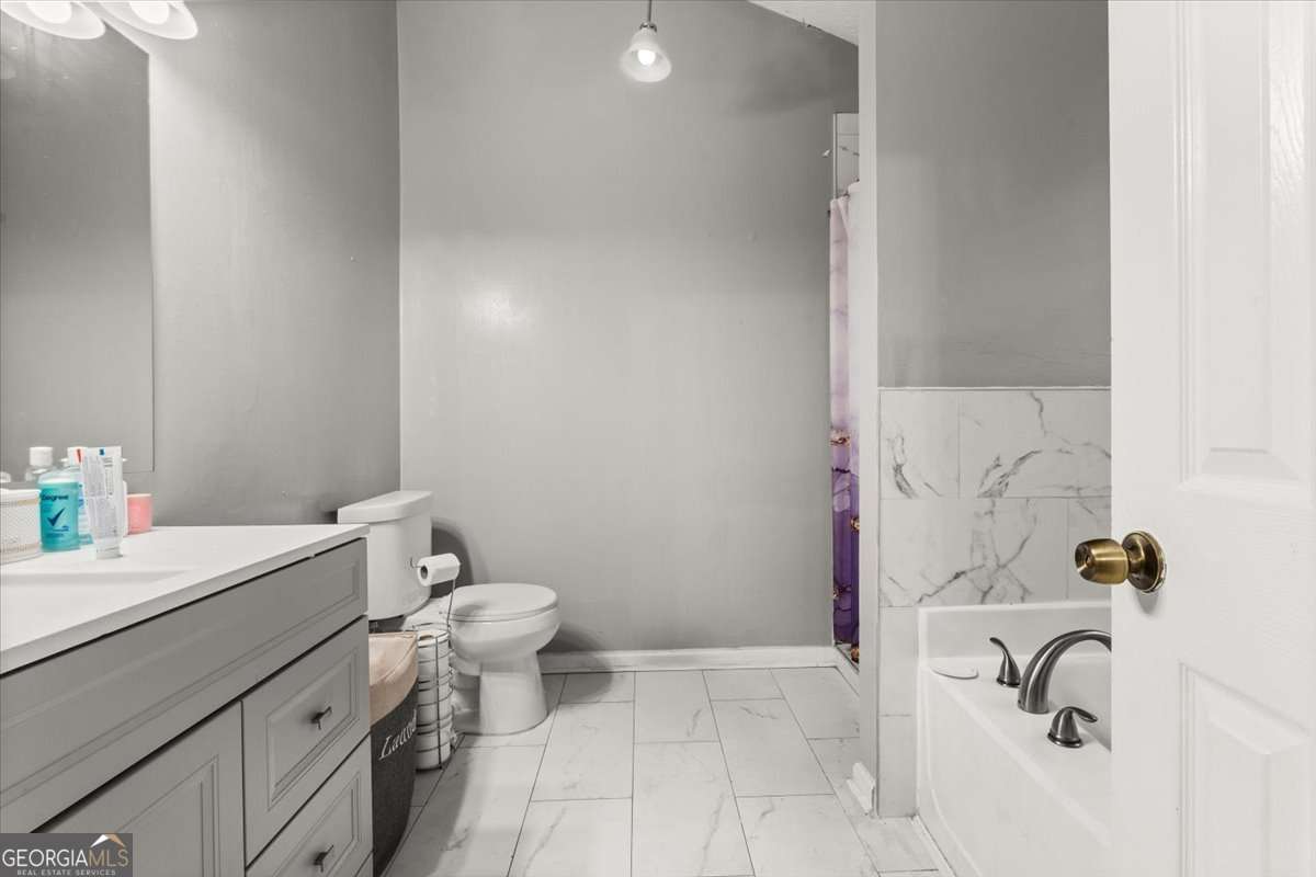1362 Tara Road Jonesboro, GA 30238 - Photo 19 of 30 a bathroom with a sink a toilet and a tub