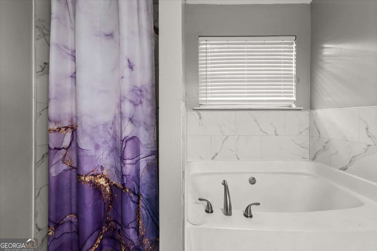 1362 Tara Road Jonesboro, GA 30238 - Photo 20 of 30 a bathroom with a bathtub and a window