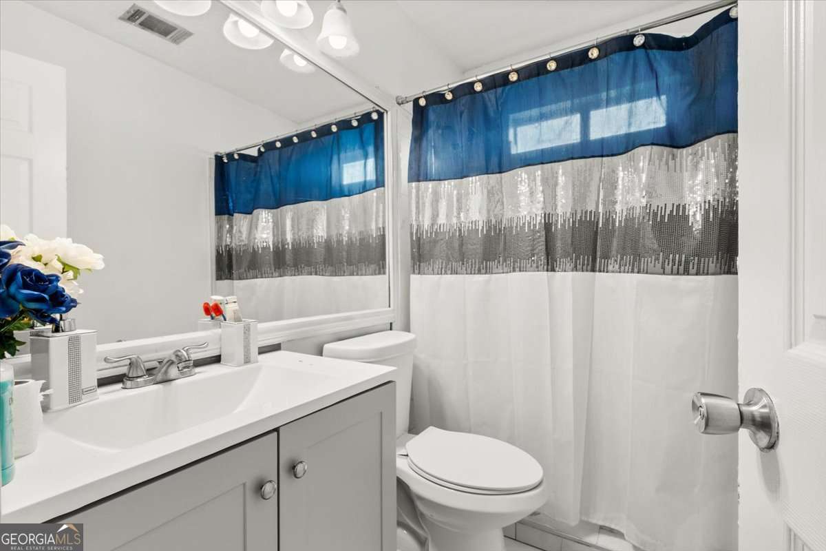 1362 Tara Road Jonesboro, GA 30238 - Photo 23 of 30 a bathroom with a sink a toilet and a mirror