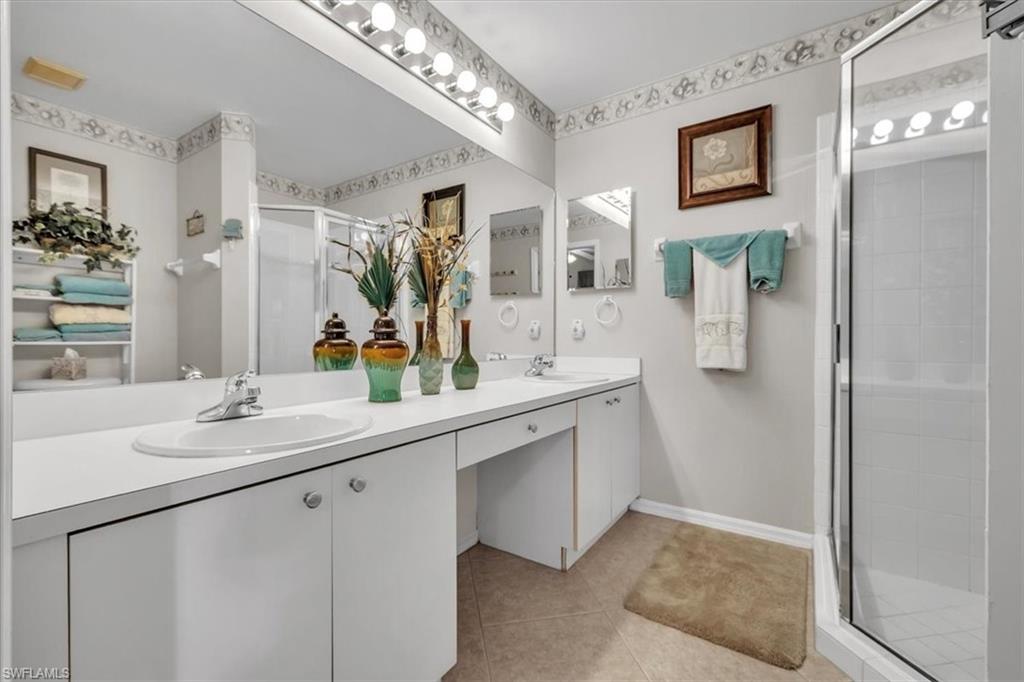 8075 Tiger Cove, Unit 1706 Naples, FL 34113 - Photo 20 of 50 Bathroom with a stall shower, double vanity, and light tile patterned floors