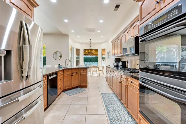 a kitchen with stainless steel appliances granite countertop a refrigerator and a stove top oven
