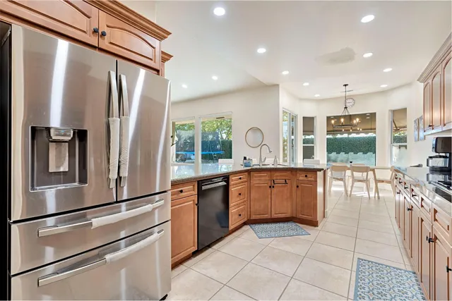 a kitchen with stainless steel appliances granite countertop a refrigerator and a sink