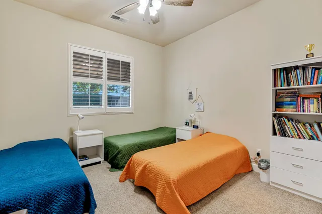 a bedroom with a bed a dresser and a book shelf