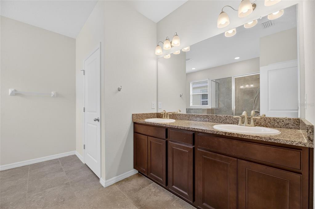 6309 Shadowlake Drive Apollo Beach, FL 33572 - Photo 22 of 64 a bathroom with a granite countertop double vanity and a mirror