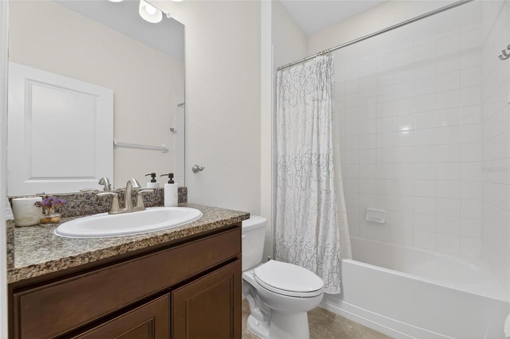 6309 Shadowlake Drive Apollo Beach, FL 33572 - Photo 32 of 64 a bathroom with a granite countertop sink toilet a mirror and shower