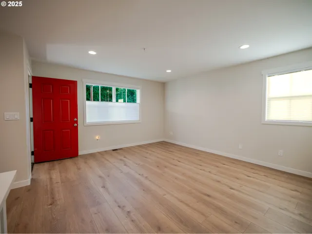 an empty room with wooden floor and window
