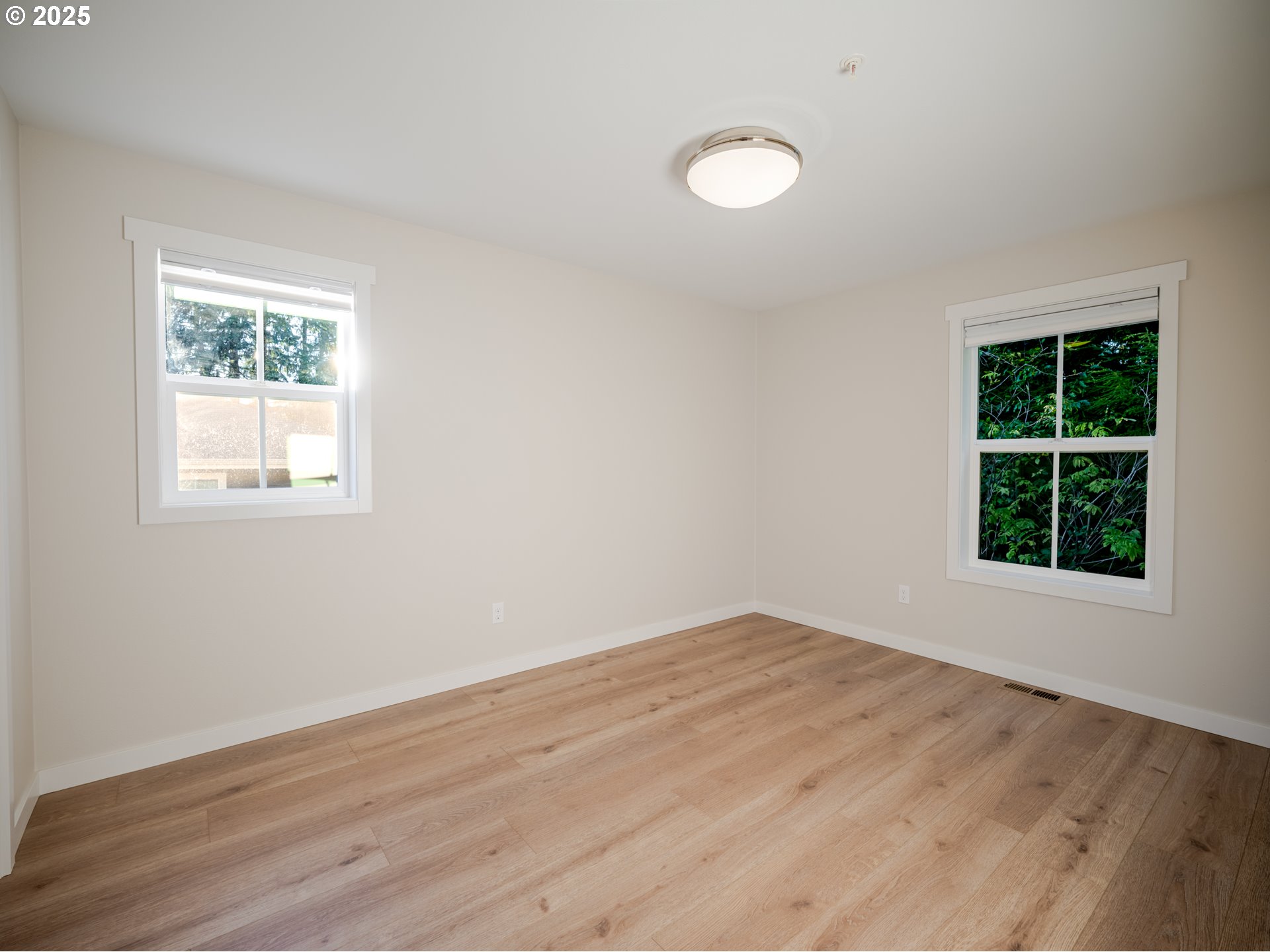 420 Elk Creek Road, Unit 401 Cannon Beach, OR 97110 - Photo 24 of 31 an empty room with wooden floor and windows
