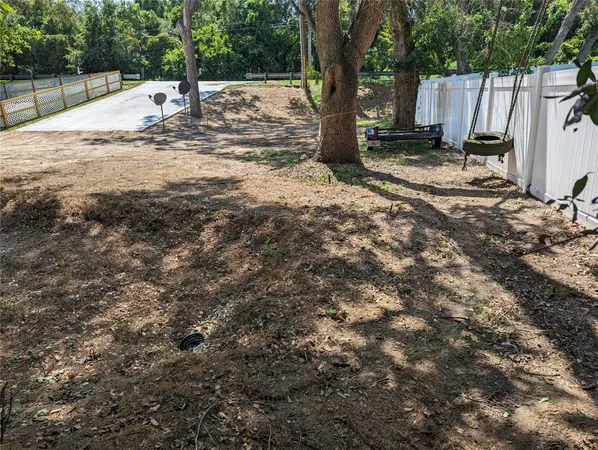a view of a yard with wooden fence