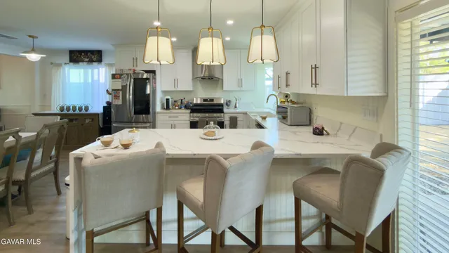 a dining room with furniture a large window and stainless steel appliances